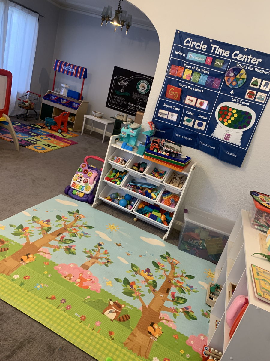 The indoor play area with a circle-time rug and low shelves